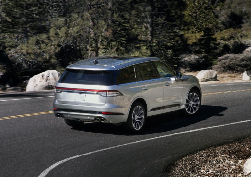 A 2023 Lincoln Aviator® Grand Touring model is shown being driven on a tight turn of a mountain road | Joe Cooper Lincoln of Edmond in Oklahoma City OK