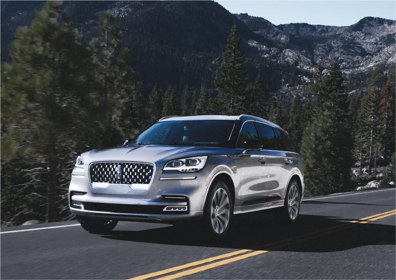 A 2023 Lincoln Aviator® Grand Touring SUV being driven on a winding road to demonstrate the capabilities of all-wheel drive | Joe Cooper Lincoln of Edmond in Oklahoma City OK