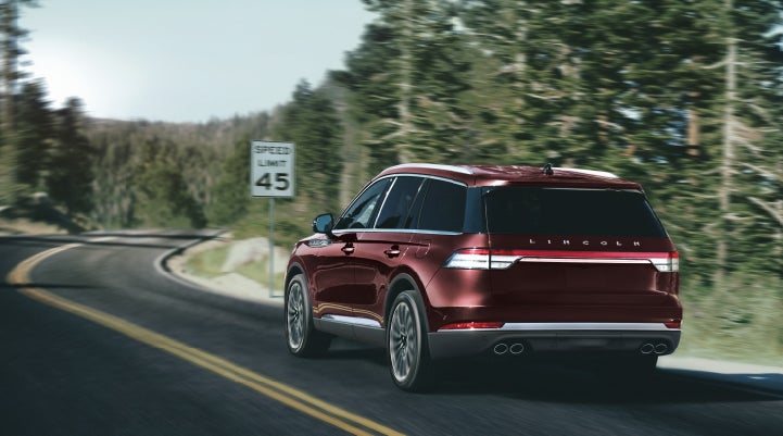 A 2024 Lincoln Aviator® SUV is being driven on a winding mountain road | Joe Cooper Lincoln of Edmond in Oklahoma City OK