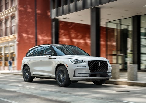 The 2024 Lincoln Corsair® SUV with the Jet Appearance Package and a Pristine White exterior is parked on a city street. | Joe Cooper Lincoln of Edmond in Oklahoma City OK